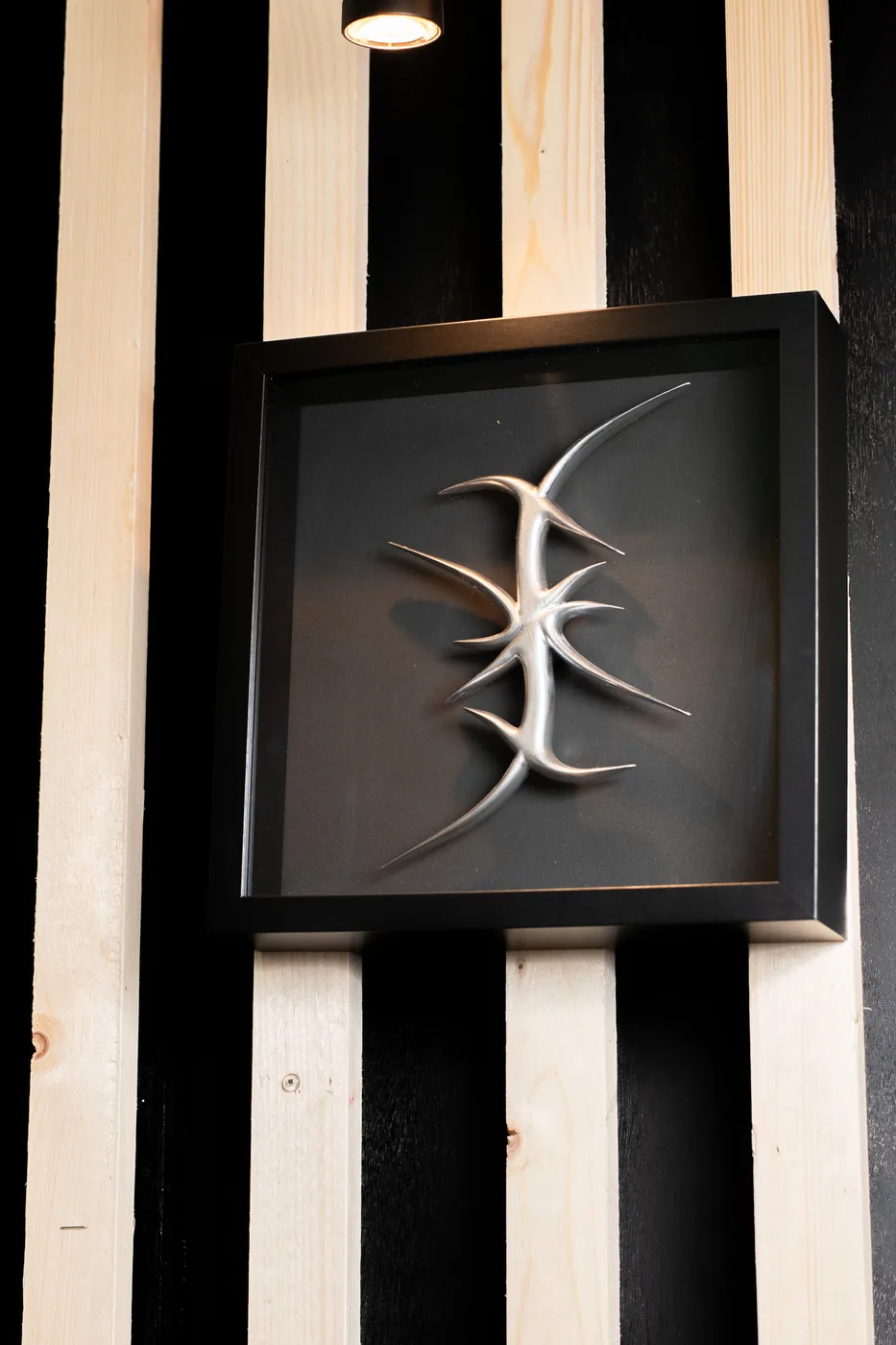 The thorn symbol framed on the striped wall
