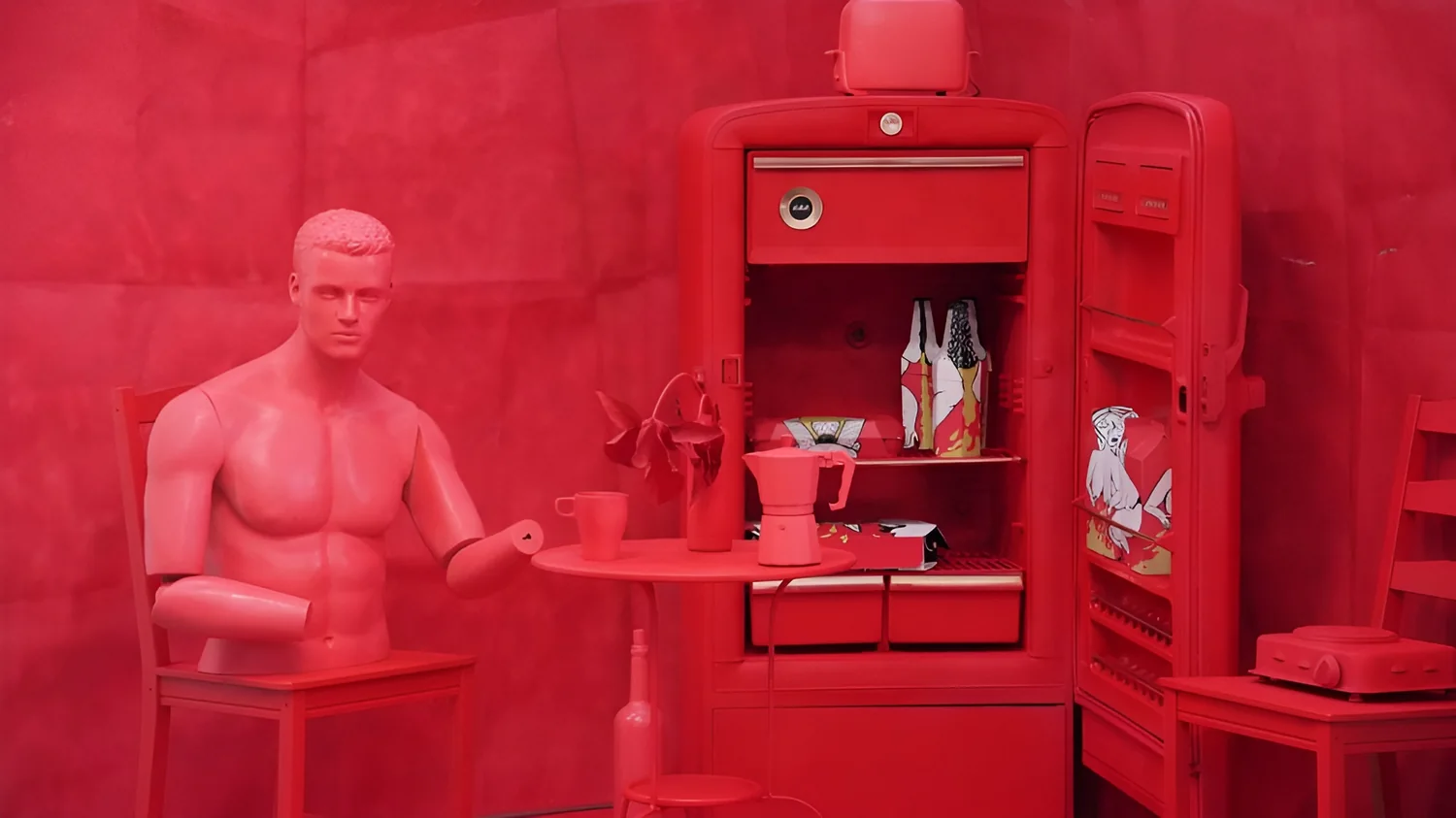 The figure seated at the red table